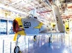 A gray airplane with yellow accent and a yellow lightening bolt on it on the hanger deck at The Intrepid Sea, Air & Space Museum.