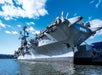 View looking up at The Intrepid Sea, Air & Space Museum from the water below on a bright sunny day in New York City.