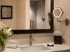 Fresh towels, vanity mirror, and bathroom amenities inside a private bathroom.
