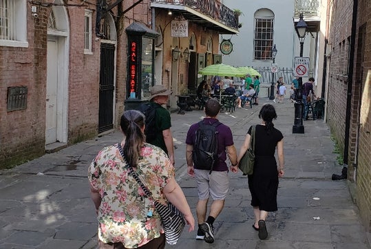 Guests walk near a Real Estate office in the French Quarter