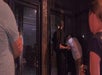 Two men peaking through a glass door at night while on the Los Angeles Ghost Hunting Tour