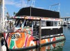 A cruise boat with geometric patterns of bright orange, teal, and magenta as part of the Fiesta Cruises - Disco Party Cruise.