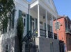 A white house with concrete streps with black railing leading up to it on the Beauregard-Keyes Historic House Tour.
