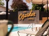 Outdoor pool area at The Ozarker Lodge, featuring lounge chairs and umbrellas beside the pool.