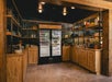 A store room area with shelves of snacks and two refrigerators full of cold beverages, and deli snacks, as well as souvenir items.
