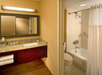 Private bathroom with vanity area, bathtub and fresh towels.