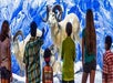 Six children observe a display of large horned mountain goats against a snowy backdrop.