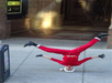 The dancer is dressed in Santa costume doing a head spin in a New York alley, entertaining the guests on The Ride.