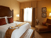 One king bed and an arm chair with ottoman inside a non-smoking room.