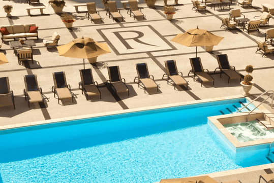 Outdoor pool with sun loungers.