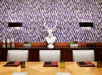 A conference room with purple wallpaper, brown cabinets, a bust of a deer, a light brown table with silver chairs around it.
