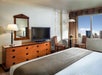 One king bed, a flat screen TV, and blackout drapes inside a guest room.
