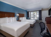 Comfort and convenience with two queen beds, a work desk, and TV.