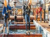 A woman in a harness standing on a log in the water with other behind her at Paula Deen's Lumberjack Feud Adventure Park.