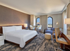 King Junior Suite with one king bed, seating area, and desk.