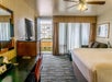 Guest room with one king bed, flat-screen TV, work desk with chair, and balcony.
