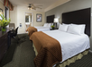 Two queen beds and a work desk inside a guest room.