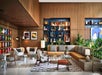 Stylish lobby with modern furniture, wall art, decorative shelving, and various plants, creating a welcoming atmosphere.