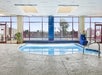 A small indoor pool with a wall of windows over it leading to the outdoor pool at Thousand Hills Resort Hotel.
