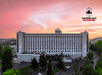 Exterior of the Thousand Hills Resort Hotel  with a pink sun set in a cloudy sky behind it in Branson, Missouri.