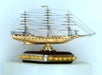 A miniature model of a tall ship with detailed rigging, mounted on a decorative base with a row of gold-colored beads.