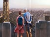 A man and woman facing away from the camera looking over the city at the Top of the Rock Observation Deck.