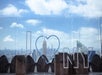 The glass partitions at Top of the Rock Observation Deck with "I Heart NY" on them on a sunny day in New York City.
