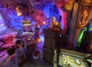 A dimly lit room with treasure chests, gold coins, a skull, colorful lighting, and mystical decorations.
