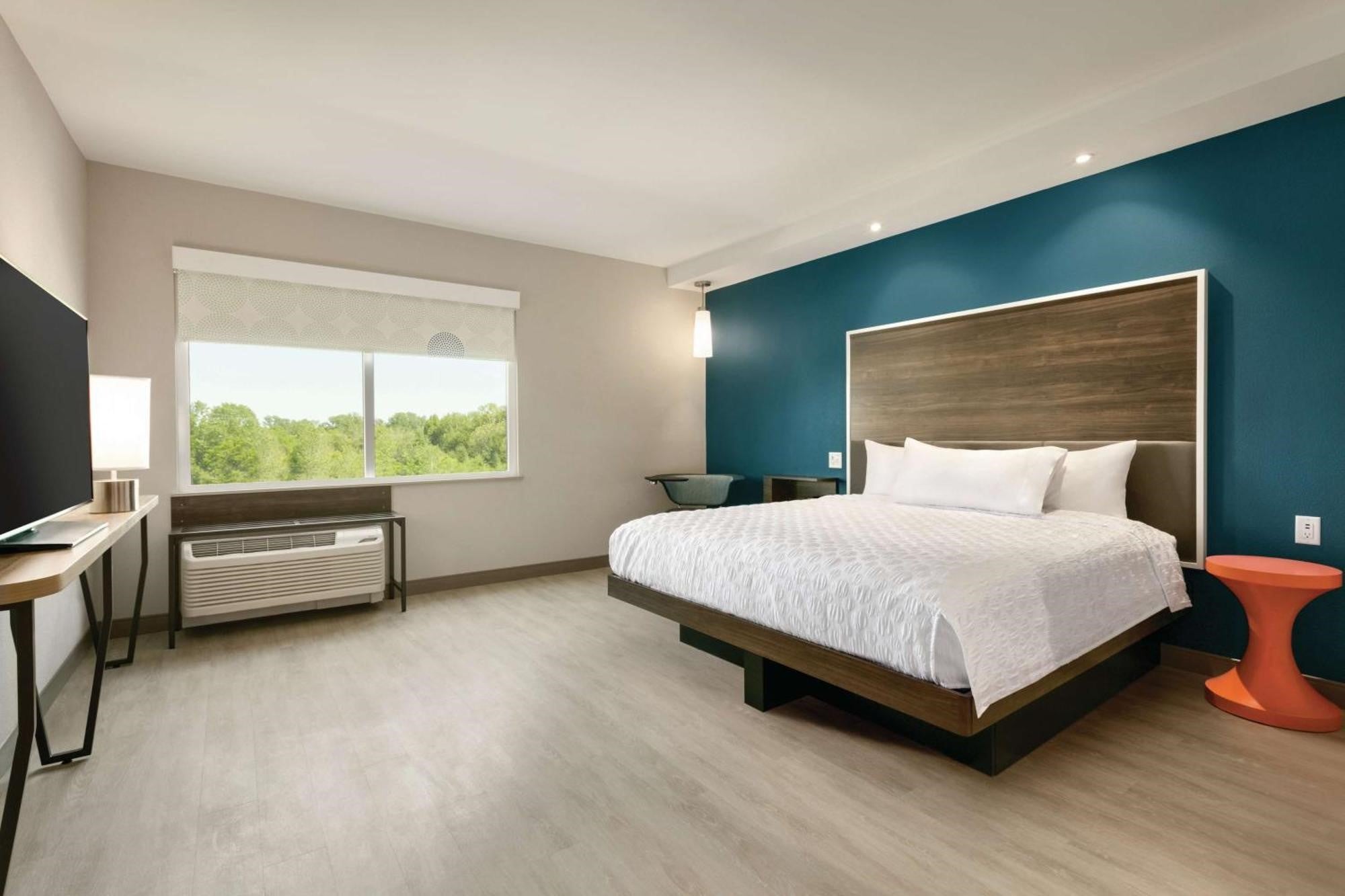 King guest room at Tru by Hilton Charlotte Ayrsley with teal accent wall and modern furnishings