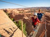 Traverse a 100-foot suspension bridge spanning the gap between two sandstone fins.