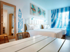 Two Queen beds and a dining area inside a guest room.