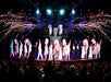 The cast of VEGAS! THE SHOW on stage in all white with streamers shooting off over their heads.