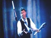 A man in a white shirt with a black vest juggling pins on stage at V - The Ultimate Variety Show in Las Vegas, NV.