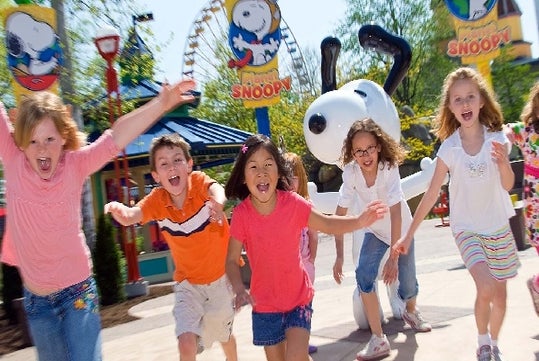 Children running in front of a statue of Snoopy at Valleyfair in Bloomington, Minnesota.