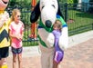 A young girl giving Snoopy a hug on a sunny day at Valleyfair in Bloomington, Minnesota.