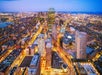 View looking down on the city of Boston at dusk with all the city lights on from View Boston Observatory.