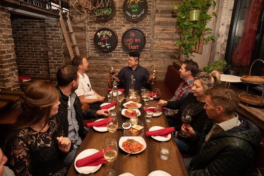 A group on the tour eats Italian food while drinking wine