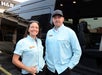 A man and woman standing in front of a bus.