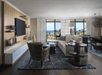 Living area with sofa bed and flat-screen TV inside a guest room.