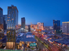 Aerial view of Las Vegas Strip at dusk, featuring brightly lit skyscrapers, hotels, and bustling streets below.