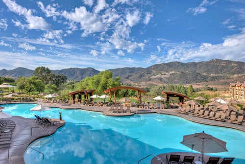 Outdoor pool with sun loungers and cabanas with a gorgeous view of the hills of Escondido at Hyatt Vacation Club at The Welk in Escondido, CA.