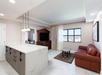 Spacious living area and kitchen with an island with 4 bar stools.