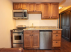 A kitchen with microwave, mini fridge, and a stovetop inside an accommodation.