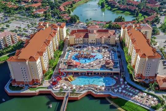 Stunning aerial view of the resort with a refreshing outdoor pools, waterpark, and a lake to enjoy.