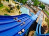 Four teenage boys going down a water slide on their stomachs at White Water in Branson, Missouri.