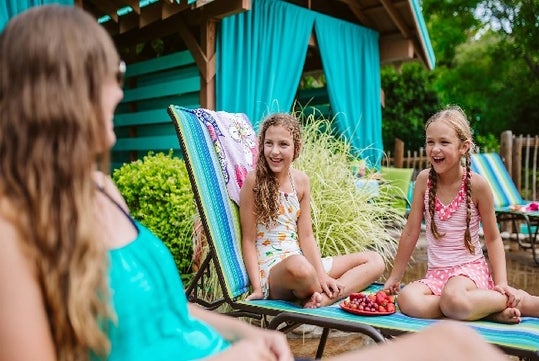 Young girls lounging and laughing near the cabanas at White Water in Branson, Missouri.