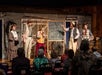 Five people on stage looking at a chalk board at WhoDunnit Hoedown Murder Mystery Dinner Show in Branson, Missouri.