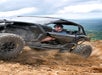Driver kicks up dirt on rugged mountain trail.
