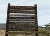Wooden town sign for Chloride, Arizona, lists population, year established, and community organizations, including church, fire department, and historical society, against a desert backdrop.