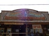 View looking up at an old western style sign for the Olive Oatman Restaurant and Ice Cream Saloon.